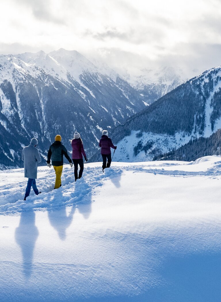 Winterwanderung mit Weitblick über verschneite Alpenlandschaft | © Winterwanderbilder (c) Gerald Oberreiter Vier Personen wandern durch frischen Pulverschnee mit Blick auf verschneite Berggipfel und winterliche Alpenlandschaft. | © Winterwanderbilder (c) Gerald Oberreiter